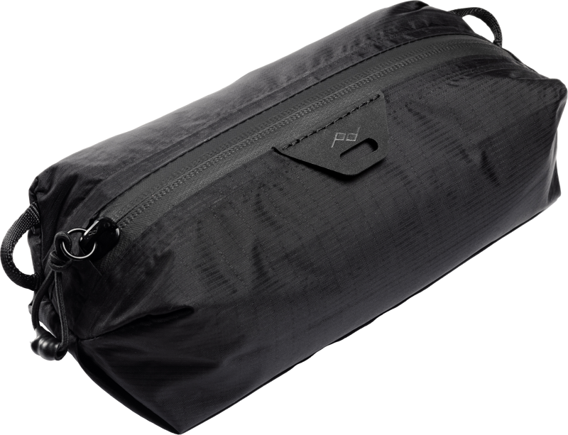 Peak Design Ultralight Packing Cube XX-Small Black on tyylikäs, musta suorakaiteen muotoinen laukku, jossa on vetoketju ylhäällä, minimalistinen muotoilu, pieni logo vetoketjun lähellä ja silmukat molemmissa päissä helppoa kantamista varten.