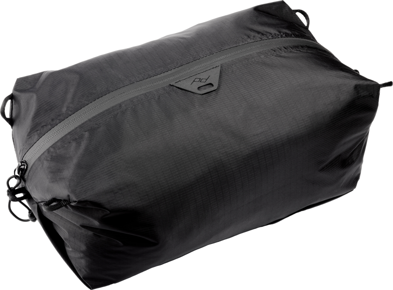Peak Design Ultralight Packing Cube Small Black on kevyt, vedenkestävä suorakulmainen pussi, jossa on hienovarainen ruudukkokuvio, musta väri, vetoketju ja pieni logo vetoketjun lähellä.