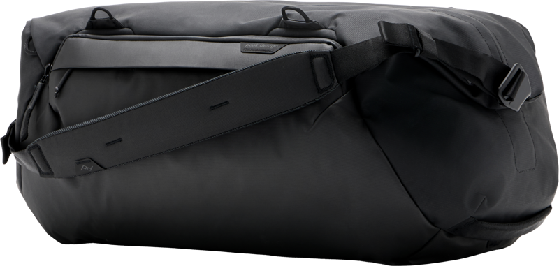 Mustassa Peak Design Travel Duffel 50L -matkakassissa on tyylikäs muotoilu, jossa on vetoketjutasku, kahvalliset hihnat ja säädettävä olkahihna, kuvassa valkoisella pohjalla.