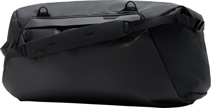 Mustassa Peak Design Travel Duffel 80L -matkalaukussa on tilava muotoilu, leveä säädettävä olkahihna ja minimalistinen tyyli, kuvassa valkoista taustaa vasten.