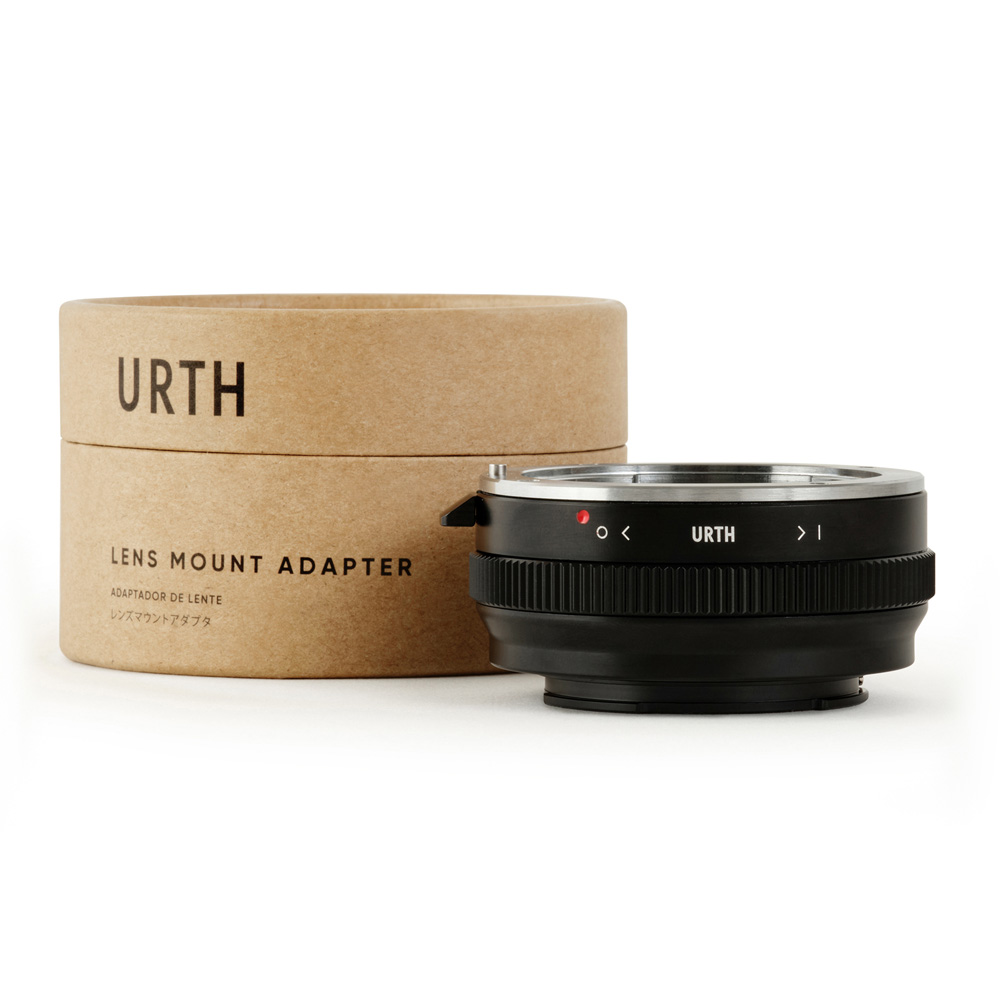 The black Urth Sony A (Minolta AF) - Sony E Lens Mount Adapter appears before its cylindrical brown cardboard box marked URTH Lens Mount Adapter, both against a white background.