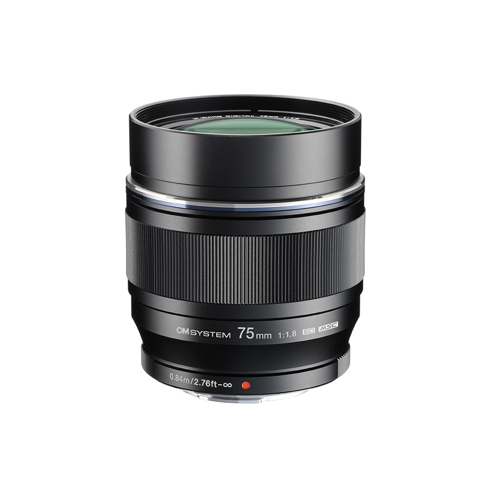 Musta OM System M.Zuiko Digital ED 75mm f/1.8 -objektiivi seisoo pystyasennossa valkoisella taustalla korostaen objektiivin lasia, tarkennusrengasta ja kaiverrettuja piipun tietoja.