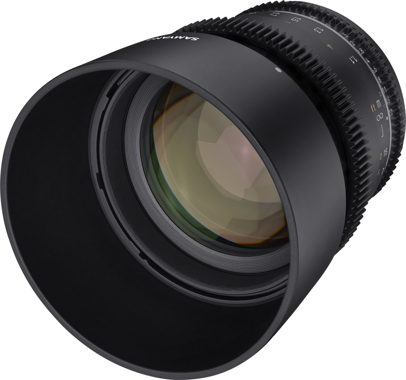Lähikuvassa Samyang 85mm T1.5 VDSLR MK2 for Canon EF -objektiivista näkyy sen musta runko, kuvioidut tarkennus- ja aukkorenkaat sekä yksityiskohtaiset lasielementit pienessä kulmassa.