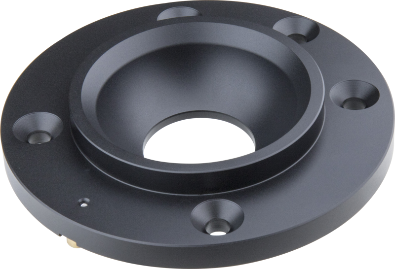 KUPO KS-658 Mitchell to 100mm Bowl Adapter on musta, pyöreä metallikomponentti, jossa on suuri keskireikä, syvennetty sisäosa ja neljä tasaisin välimatkoin olevaa ulkoreikää, joita käytetään Mitchell-kiinnikkeiden sovittamiseen 100 mm:n kulhoihin laitteissa.