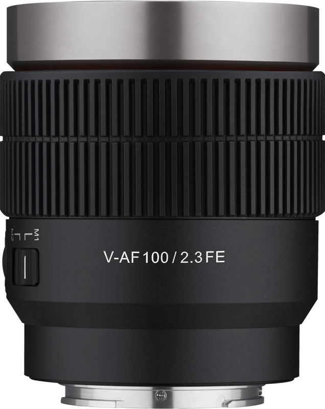 A close-up of the Samyang V-AF 100mm T2.3 - Sony FE lens shows the "V-AF100 / 2.3 FE" marking, the textured focus rings and adjustment rings, and the shift switch on the left.