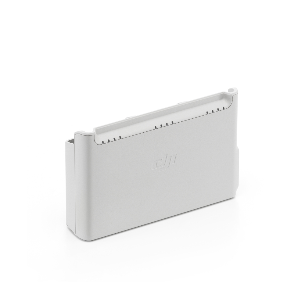 Harmaa suorakaiteen muotoinen DJI Neo Two-Way Charging Hub -lataustelakka, jossa on pyöristetyt reunat, jäähdytysaukot ylhäällä ja DJI-logo kohokuvioitu etupuolella, kuvassa valkoista taustaa vasten.