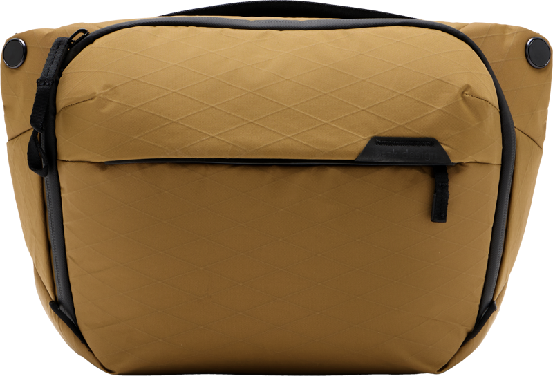 Peak Design Everyday Sling v2 6L in Coyote on strukturoitu, sinapinkeltainen crossbody-laukku, jossa on timanttikuvioinen rakenne, mustat korostukset, vetoketjullinen etutasku ja musta yläkahva.