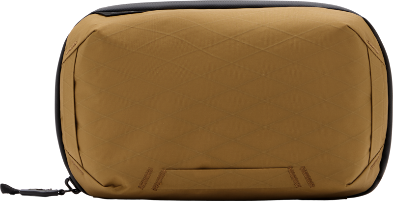 The Peak Design Tech Pouch - Coyote is a rectangular brown pouch with a subtle diamond patterned texture, black zipper and a small fabric loop on one side.