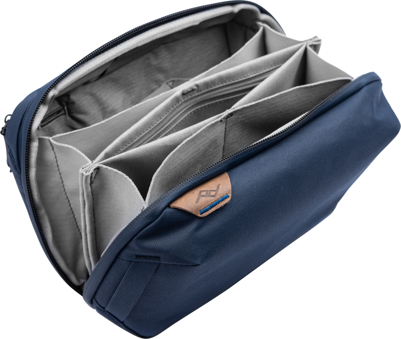 Peak Design Tech Pouch - Midnight is a blue and grey zippered organizer with adjustable padded compartments, perfect for safely storing and protecting small items such as camera equipment or electronics.