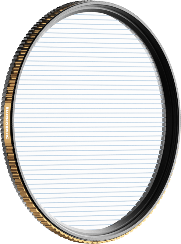 PolarPro Quartzline BlueMorphic -suodattimen 67 mm:n lähikuvassa, pyöreässä linssisuodattimessa, jossa on kultainen ja musta harjattu reuna, jossa on merkintä "ANAMORPHIC", näkyy vaakasuoria sinisiä viivoja sen läpinäkyvän lasin poikki.