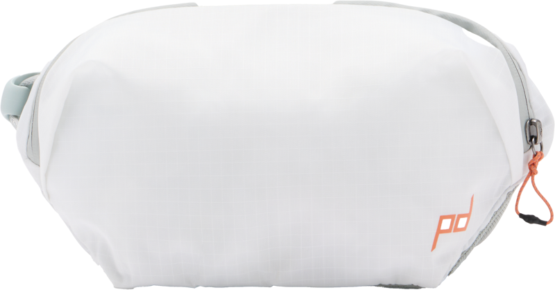 Peak Design Outdoor Sling 2L - Cloud on valkoinen, suorakulmainen rintareppu, jossa on oikeanpuoleinen vetoketju, minimalistinen muotoilu, vaaleanharmaat korostukset ja pieni oranssi pd-logo oikeassa alakulmassa.