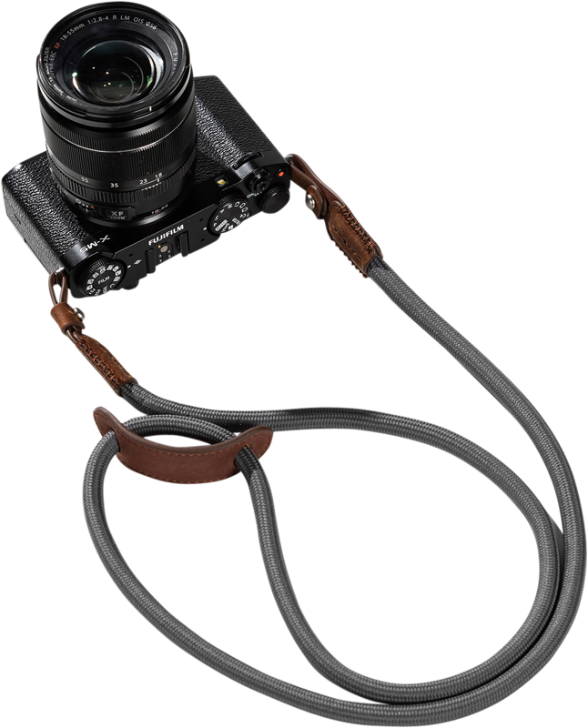 The white background shows a black Fujifilm camera with lens attached to a grey SmallRig 5057 Universal Braided Shoulder Strap with brown leather trim.