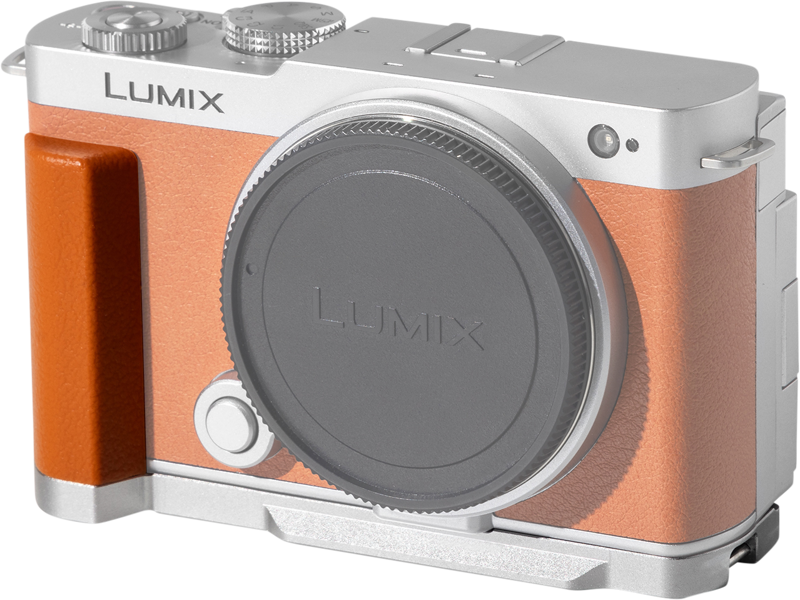 SmallRig 5052 L-muotoinen kahva Panasonic LUMIX S9:lle - Oranssi rajoitettu painos on kuvassa kiinnitettynä hopeanväriseen kameraan, jossa on oranssinruskea kahva ja linssinsuojus, edestäpäin vaaleaa taustaa vasten.