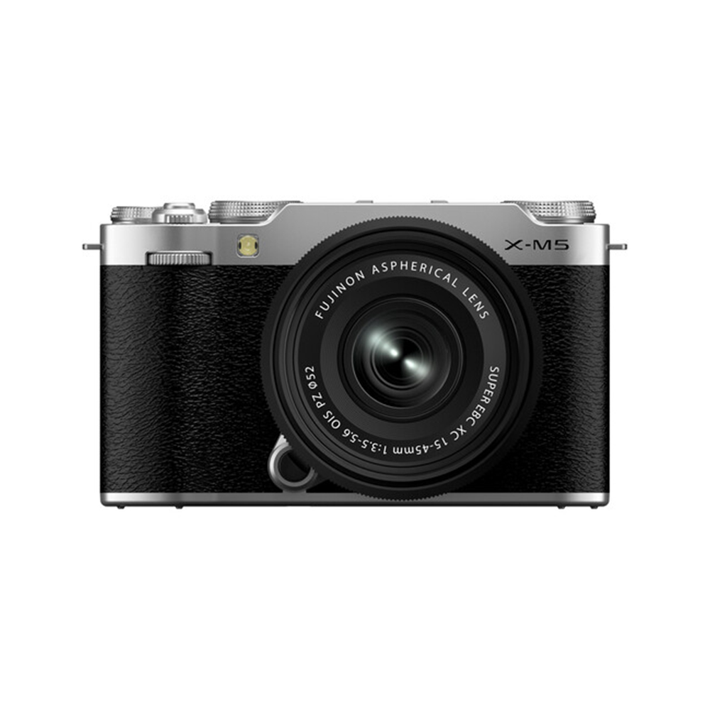 Fujifilm X-M5 + XC 15-45mm f/3.5-5.6 (Hopea) -digitaalikameran etukuva, jossa on musta runko, hopeinen yläosa ja suuri asfäärinen Fujinon-objektiivi.