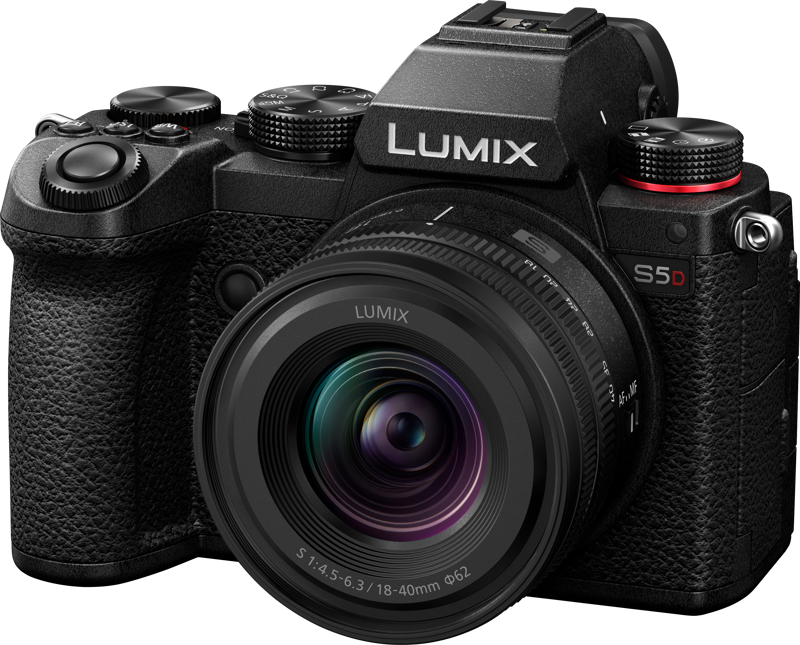 Musta Panasonic Lumix S5D + 18-40mm f/4.5-6.3 -kamera, jossa on suuri objektiivi, useita säätöpyöriä, kuvioitu kahva ja punainen korostus suljinpainikkeen vieressä, oikeasta etukulmasta katsottuna.