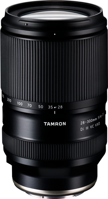 Musta Tamron 28-300mm f/4-7.1 Di III VC VXD -objektiivi (Sony E), jossa on valkoinen merkintä, näkyy valkoisella taustalla, ja siinä on kuvioidut tarkennusrenkaat ja zoomausrenkaat sekä tyylikäs, moderni muotoilu.