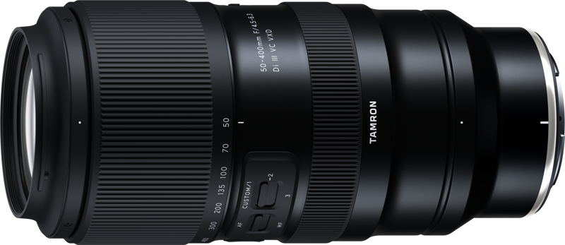 Tamron 50-400mm f/4.5-6.3 Di III VC VXD -objektiivissa Nikon Z:lle, musta, on zoomaus- ja tarkennusrenkaat, polttovälimerkinnät 50-400mm, sivukytkimet ja USB-portti, kuvassa valkoista taustaa vasten.