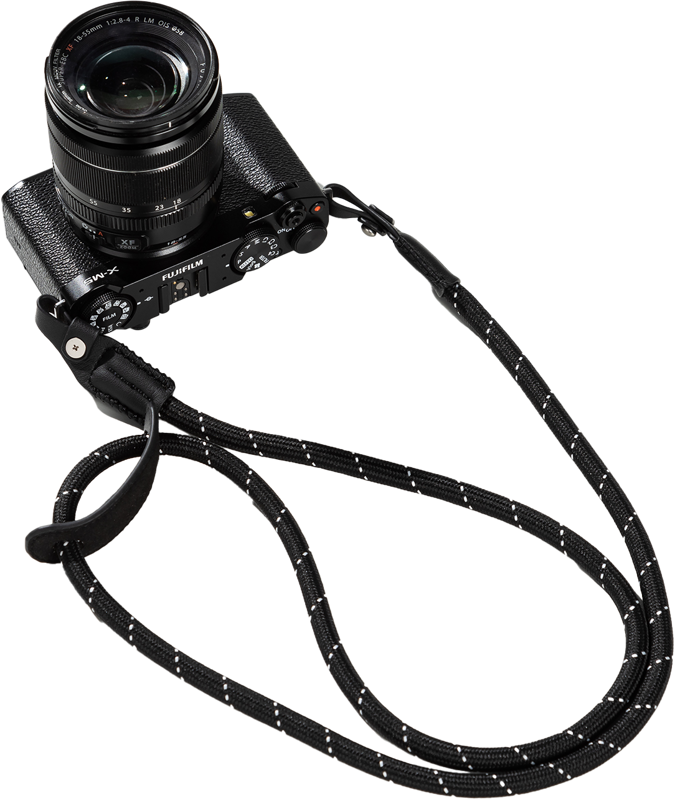 Musta Fujifilm-kamera ja objektiivi on yhdistetty SmallRig 4882 Universal Braided Shoulder Strap -kamerahihnan kanssa, jossa on valkoiset korostukset ja joka näkyy vaalealla pohjalla.