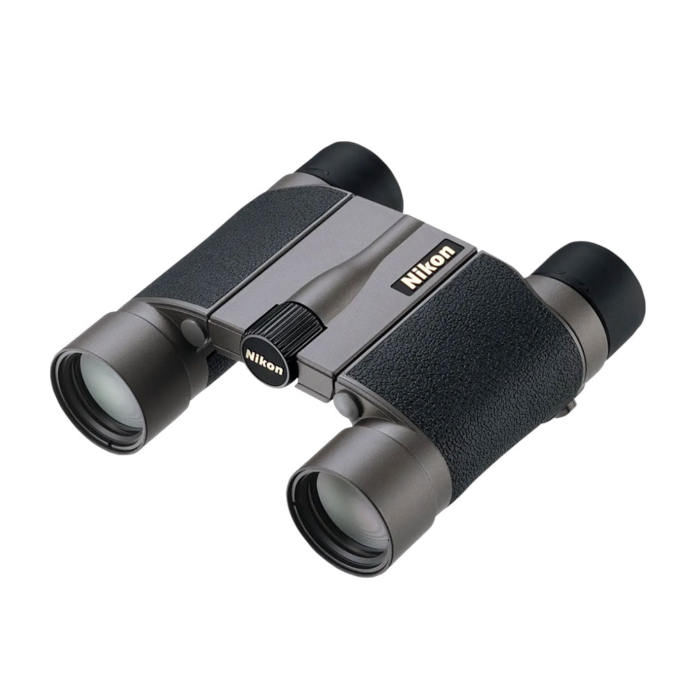 The Nikon 8x20 HG L DCF is a compact binocular with a black textured grip, metallic grey body, centre focus wheel and two large objectives. The gold Nikon logo appears on one side.