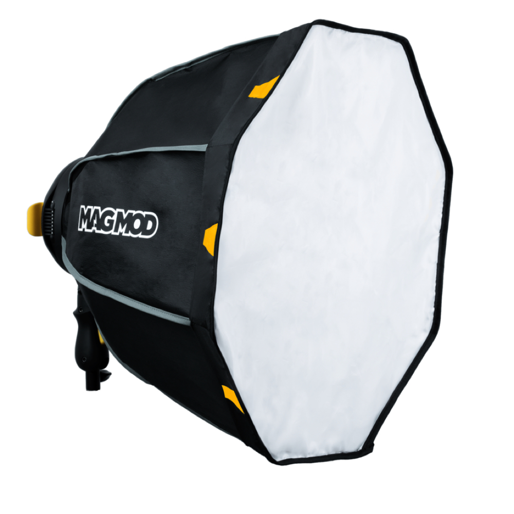 MagMod MagBox 24 Octa Profoto Gel Kit on musta kahdeksankulmainen softbox, jossa on valkoinen etudiffuusio, "MAGMOD" -merkintä sivulla, keltaiset korostukset reunoilla, ja sitä käytetään studiokuvauksen valaistukseen.