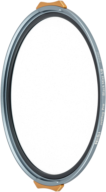 The NiSi JetMag Pro 95 Black Mist 1/8 is a round camera lens filter with a metal frame, transparent surface and two gold tabs on the edge for easy handling.