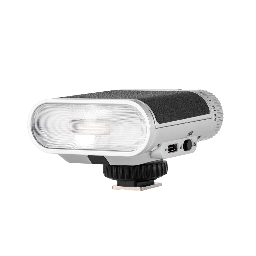 Viltrox Vintage Z1 Retro On-camera Flash -salamavalaisimessa on kompakti suorakulmainen muotoilu, jossa on kuvioitu musta ja hopeinen runko, läpikuultava etupaneeli, sivusäätöpyörä, USB-portti, ohjauspainikkeet ja alareunan kiinnike.