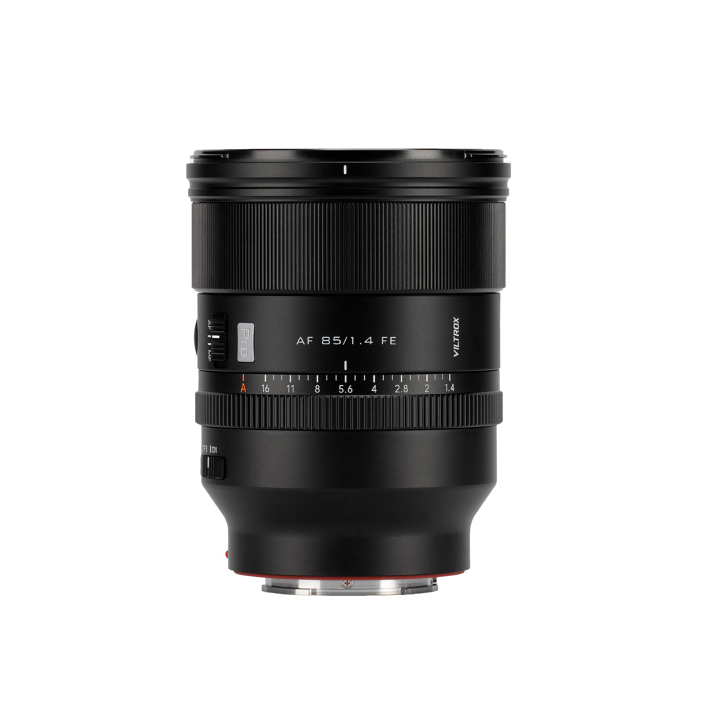 Musta Viltrox AF 85mm F/1.4 -objektiivi Sony FE:lle, jossa on tarkennusrengas ja aukkomerkinnät, piipussa merkintä "AF 85/1.4 FE", seisoo pystyssä valkoista taustaa vasten.