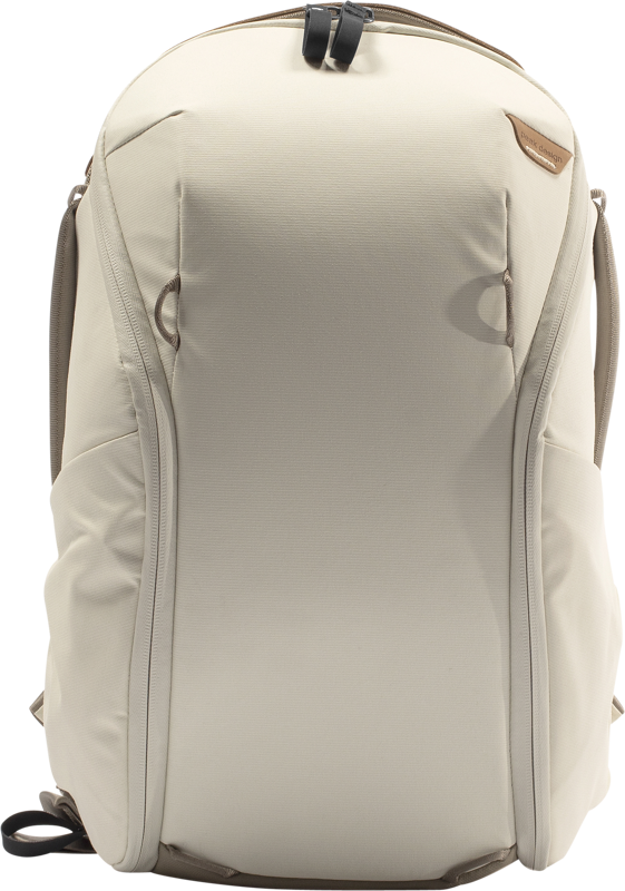 Peak Design Everyday Backpack 15L Zip V2 in Bone on tyylikäs, vaaleanbeige laukku, jossa on minimalistinen muotoilu, sivutaskut, yläkahva mustalla hihnalla ja pieni ruskea logolaastari oikeassa yläkulmassa.