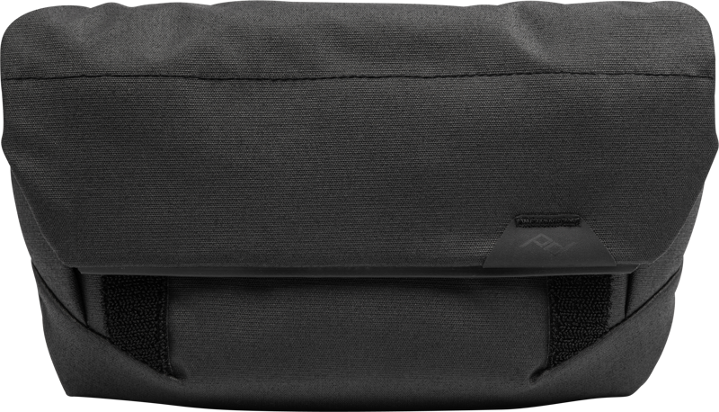 Peak Design The Field Pouch v2 mustana on tyylikäs, minimalistinen suorakulmainen kangaspussukka, jossa on läppäsuljenta ja pieni kolmionmuotoinen logo edessä, täydellinen pienten esineiden tai tarvikkeiden kuljettamiseen.