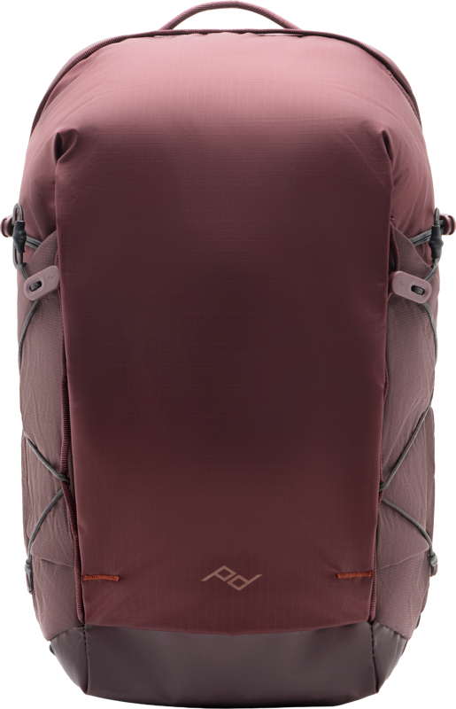 The Peak Design Outdoor Backpack Zip 18L Eclipse features a brown and dark grey minimalist design, side pockets, a small geometric front logo and elastic side straps for extra storage.