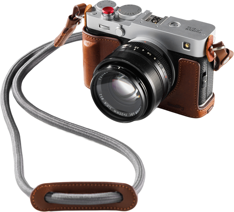 Ruskealla SmallRig 5449 -nahkakotelosarjalla suojatun FUJIFILM X-E5 -kameran parina on suuri objektiivi ja harmaa rannehihna, jossa on yhteensopiva ruskea nahkainen korostus.