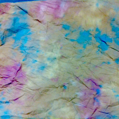 Westcott Hazel Pastel Backdrop -taustakuvassa (3 x 7,2 m) on rypytetty tie-dye-kuvio pehmeillä pastellisävyillä sinisellä, vaaleanpunaisella ja keltaisella, mikä luo abstraktin ja värikkään ilmeen.