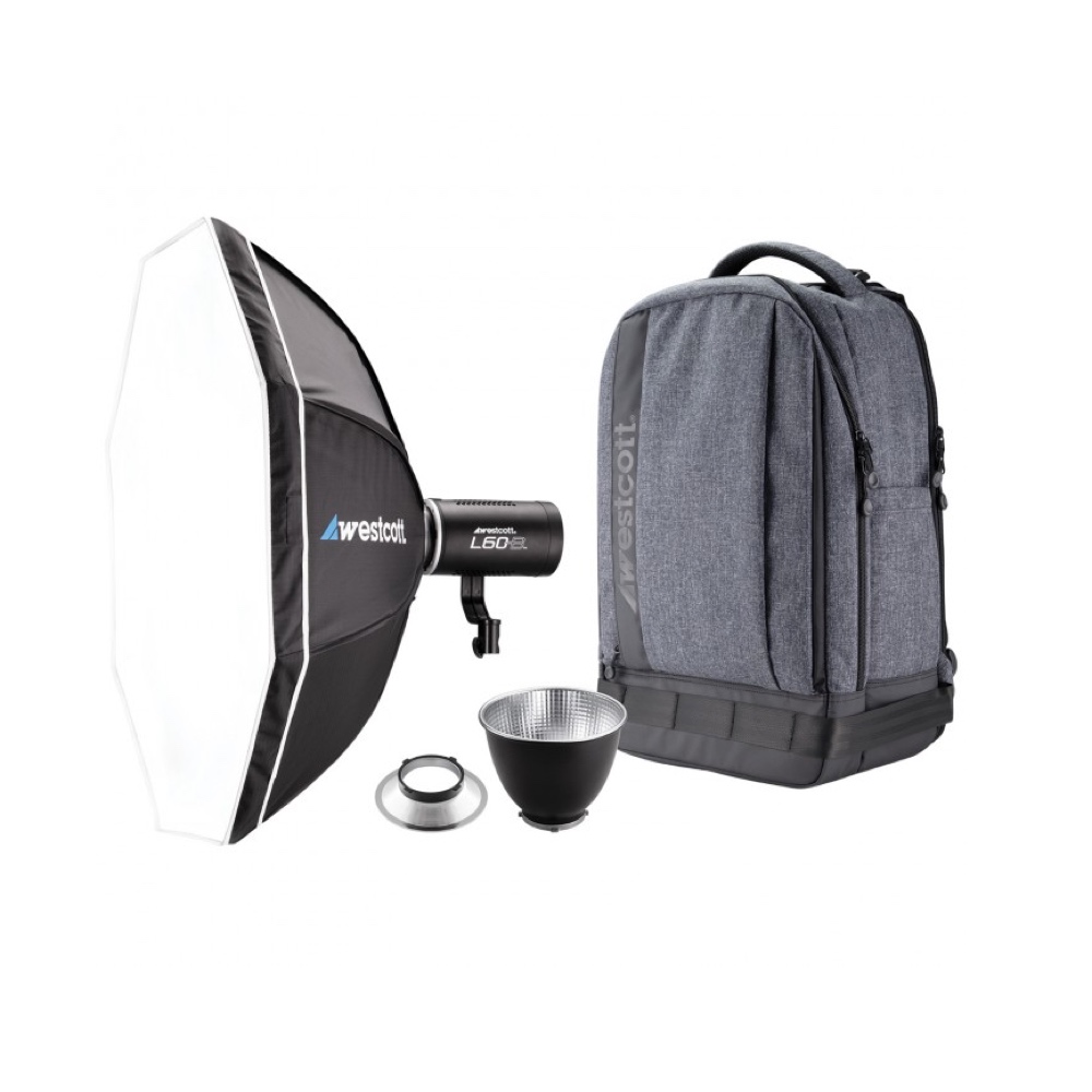 The Westcott L60-B Bi-Color COB LED 2-Light Backpack Kit includes an octagonal softbox, an LED light with reflector, an additional reflector, a small silver plate and a grey Westcott backpack, all visible on a white background.