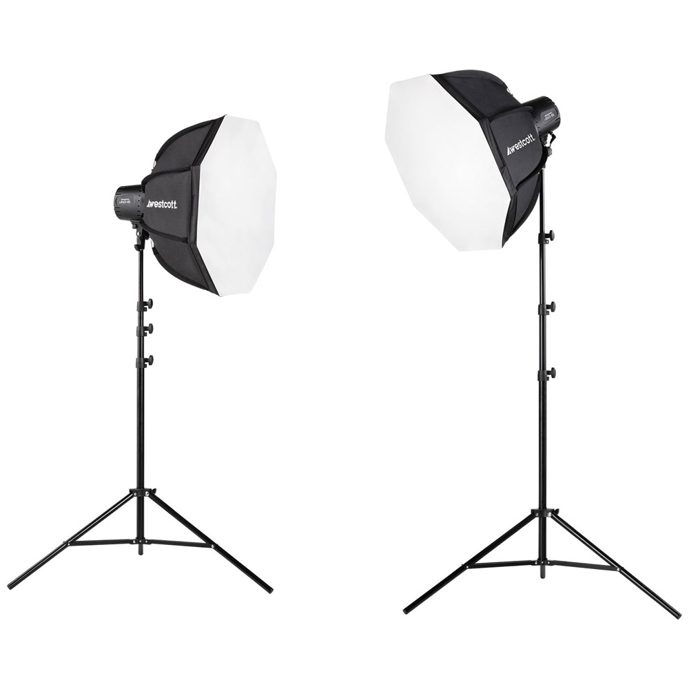 Westcott U60-B Bi-Color LED 2-Light Softbox Kitissä on kaksi mustaa studiovalotelinettä, joissa on suuret kahdeksankulmaiset valkoiset LED-softboxit, jotka on esitetty sivu- ja kulmanäkymässä valkoisella taustalla.
