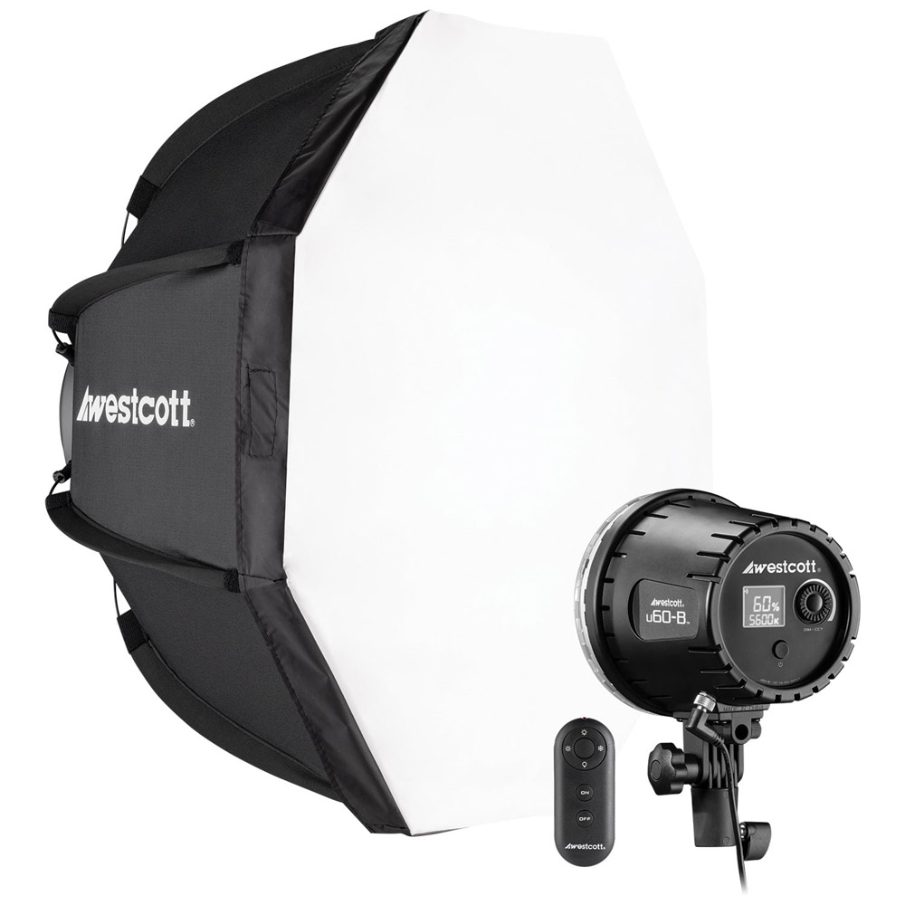 Westcott U60-B Bi-Color LED 1-Light Softbox Kit (60W) on studiovalaistussarja, jossa on suuri kahdeksankulmainen softbox, studiovalo takasäätimillä ja pieni langaton kaukosäädin, joissa kaikissa on Westcottin logo.