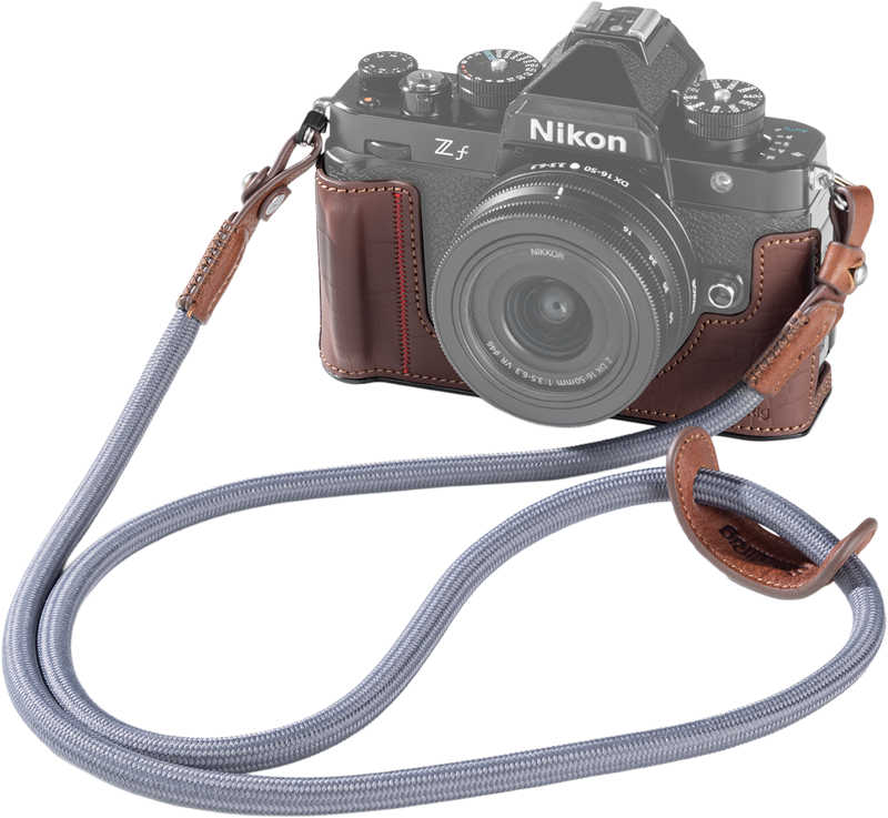 The Nikon Z f mirrorless camera with brown SmallRig 5096 leather body kit and grey cloth strap is shown against a white background.