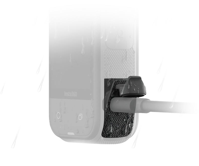 Lähikuva Insta360 X5 All-Weather USB-lataussuojasta (-latauskansi) kamerassa vesipisaroiden kanssa, jossa näkyy sivuporttiin kytketty kaapeli ja kuvioitu alue suojan lähellä.