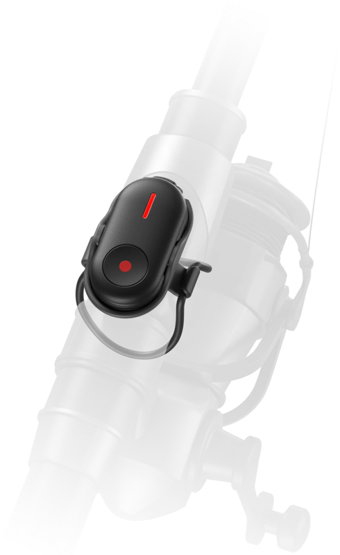 Lähikuva Insta360 Mini Remote -kaukosäädin, pieni musta laite, jossa on punainen merkkivalo ja joka on kiinnitetty taustalla sumeaan onkivapaaseen.