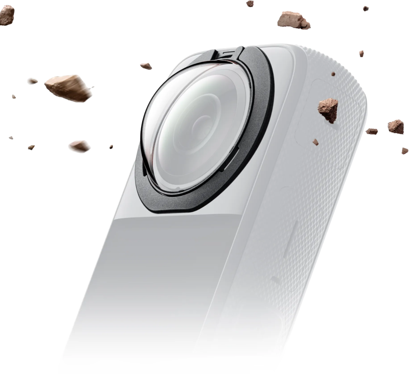 Lähikuva Insta360 X3 Premium Removable Lens Guards -linssisuojasta, valkoinen, jossa on laaja linssi, jota ympäröivät lentävät kivet vaaleanharmaalla taustalla, korostaen sen kestävää ja karua suojaa.