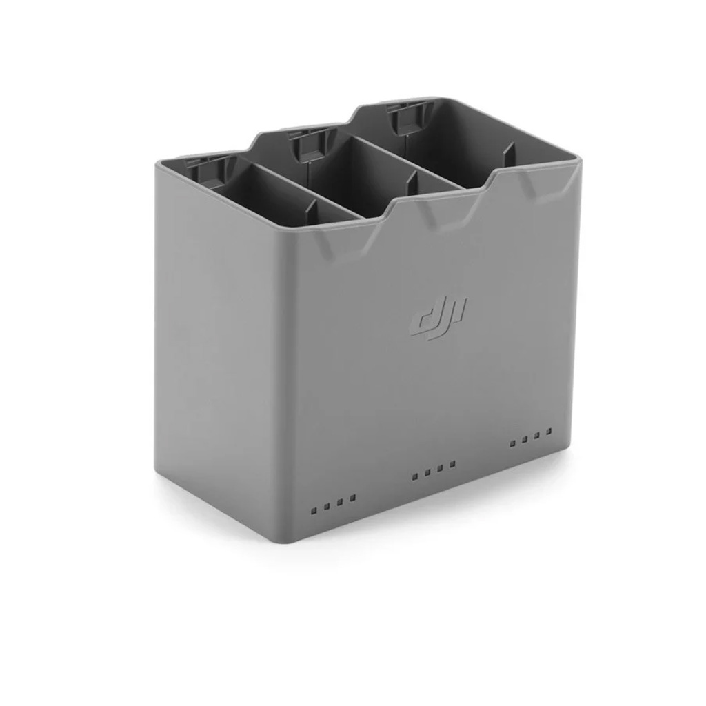 DJI Mini 5 Pro Two-Way Charging Hub -latausasema on harmaa, suorakulmainen latauskeskitin, jossa on kolme paikkaa useiden drone-akkujen lataamiseen, ja sen sivussa on DJI-logo.