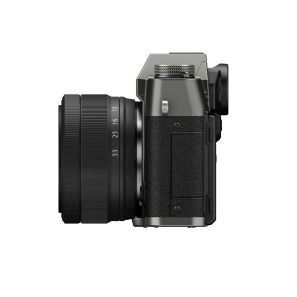 Fujifilm X-T30 III + XC 13-33mm f/3.5-6.3 OIS (harmaa) näytetään sivulta, ja siinä on suuri objektiivi, kompakti kuvioitu runko sekä useita painikkeita ja valitsimia, kaikki valkoista taustaa vasten.