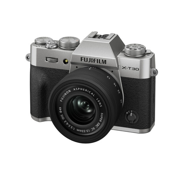 Hopeinen Fujifilm X-T30 III, jossa on XC 13-33mm f/3.5-6.3 OIS -objektiivi, on kuvattu niin, että kameran rungon ja objektiivin etu- ja vasen puoli on näkyvissä.