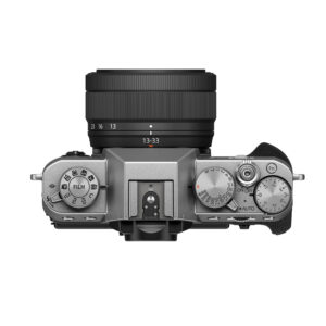 Fujifilm X-T30 III (hopea) -digitaalikameran yläkuva mustalla XC 13-33mm f/3.5-6.3 OIS -objektiivilla, jossa näkyy selkeät hallintalaitteet, toimintatilan ja suljinnopeuden valitsimet sekä oikealla puolella oleva kuvioitu kahva.