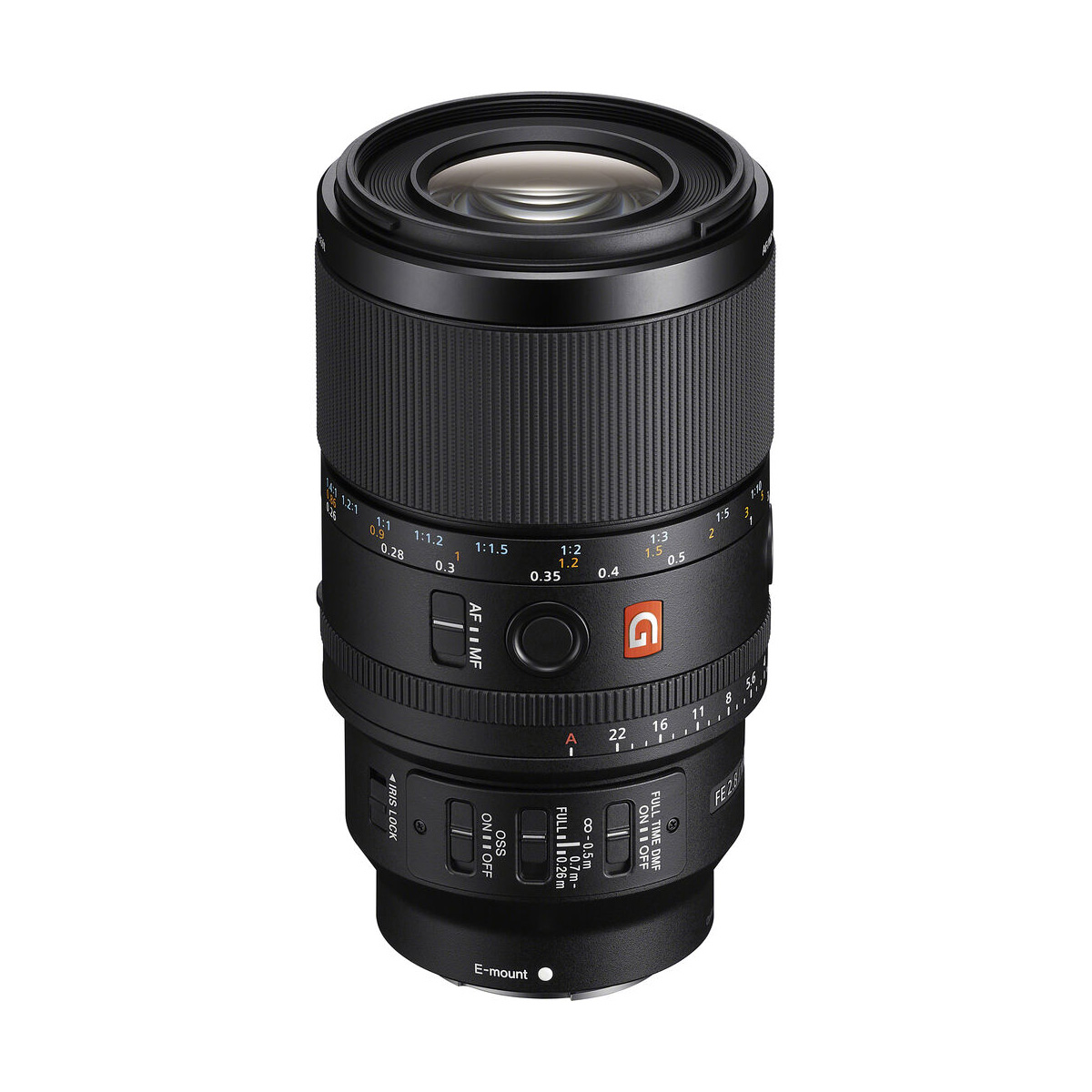 The Sony FE 100mm f/2.8 Macro GM lens is a black camera lens with textured focus and zoom rings, aperture markings, control switches and an orange G logo depicted vertically on a white background.