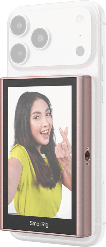 Keltaiseen paitaan pukeutunut nainen hymyilee ja tekee sormella sydäntä, kun hänen älypuhelimensa, joka on varustettu SmallRig 5746 Wireless Display Mirroring Adapter for Mobile Phone - Selfie Kit -laitteella, näkyy kameran linssit ylhäällä.