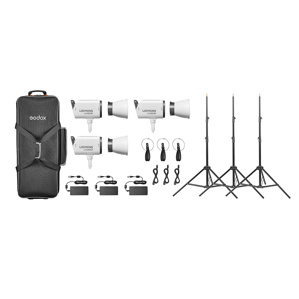 Godox Litemons LA300R RGB LED Video Light 3 Light Kit Valkoinen sisältää kolme studiovaloa, jalustat, kaukolaukaisimet, virtasovittimet, johdot ja mustan kantolaukun, jotka on järjestetty siististi valkoiselle taustalle.